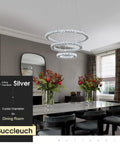 Modern LED crystal chandelier with ring lamp body dimmable 6500K cool white hanging over dining table in elegant room.