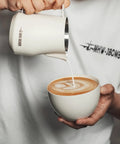 Milk Frothing Pitcher 12oz 350ml Stainless Steel For Espresso And Latte Art, Round Spout Milk Jug, White Finish, pouring into cup