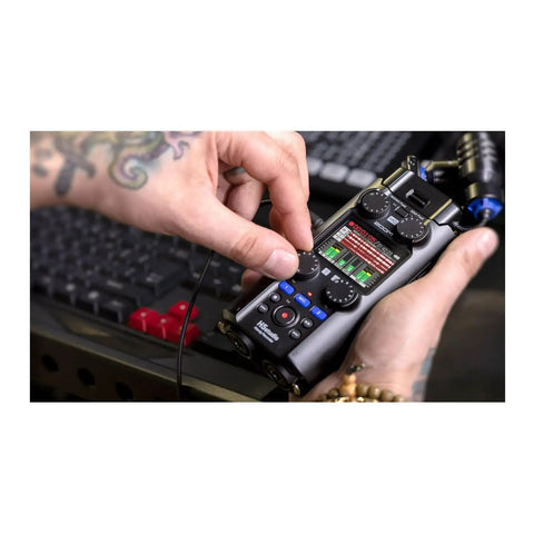 Handheld Studio Recorder For Musicians Podcasters And Filmmakers With Large Stereo Microphones Pro Quality Preamps Six Track Recording 32 Bit Float USB Audio Interface On The Go being adjusted by a hand