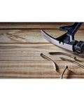 ToughSeries 22 Oz Demo Hammer With Magnetic Nail Starter Extended Claw For Board Grabbing shown pulling nails from wood surface