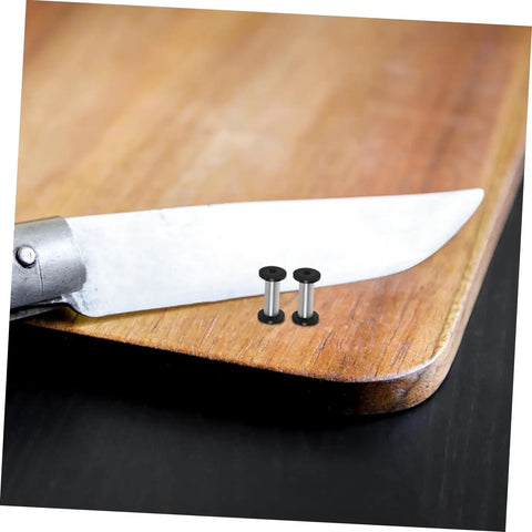 Heavy Duty Stainless Steel Bindery Rivets And Self Tapping Metal Handle Screws For Knockout DIY Crafts And Leather Work Built Like A Tank With Badass Grip Corrosion Resistant Hardware That Lasts Forever on a wooden cutting board next to a knife.