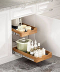 The Real Deal Heavy Duty Two Tier Pull Out Cabinet Organizer With Super Smooth Gliding Wood Shelves, featuring two wooden shelves with kitchen items.