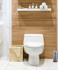Slick Brushed Metal Toilet Plunger With Spill Proof Canister And Wall Mount Holder For Bathroom Corner Storage next to white toilet.