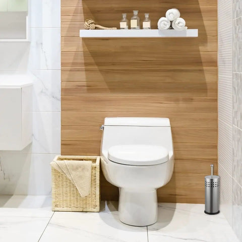 Slick Brushed Metal Toilet Plunger With Spill Proof Canister And Wall Mount Holder For Bathroom Corner Storage next to white toilet.