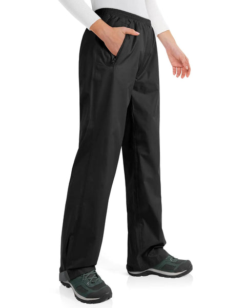 Model wearing Women Grab And Go Packable Waterproof Rain Pants Lightweight Windproof Overpants for Golf and Hiking, black, side view.