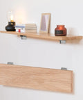 Heavy Duty Folding Brackets For Table Legs And Wall Shelves With Self Locking Hinges Rating Up To 330 Pounds Each mounted holding a wooden shelf.