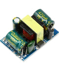 Dead Set Reliable Isolated Step Down Module AC DC Switching Power Supply Transformer Converting 220 Or 110 Volts To A Rock Solid 3.3V close-up view of power supply module with capacitors and transformer.