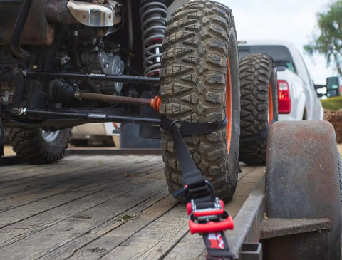 Close-up of Ultimate UTV Tie Down Kit For Trailer Transport With Tire Bonnets, showing wheel lasso strap securing tire on trailer.