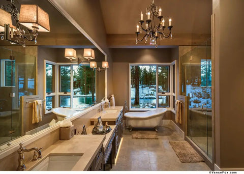 Modern bathroom with freestanding tub, large windows, and elegant lighting showcasing a cozy winter view.