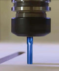 Close-up of a blue 2-flute straight CNC router bit with 1/8 in shank mounted in the spindle.