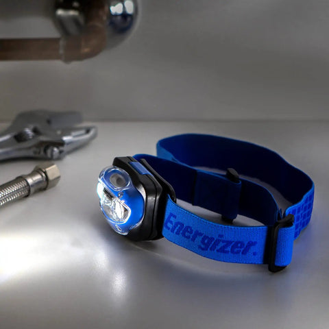 Vision LED Headlamp 200 Lumen 4 Pack With 12 AAA Batteries Included, adjustable hands-free light on table