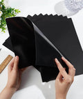 Front view of black BENECREAT laser engraving testing paper sheets, A4 11x8.3 in, double-sided, hands peeling a sheet