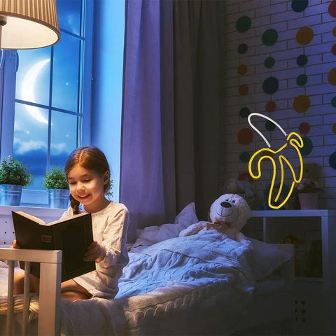 Child reading in room with Banana Neon Sign LED Light 11.4 x 7.9 Inches USB or Battery Powered Wall Decor Night Lamp on wall