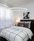 27.5 Inch LED Ring Chandelier Modern One Ring Pendant Light For Dining Room Kitchen Foyer Living Room Bedroom Hallway Warm White 3000K Non Dimmable Dope Look For Any Modern Home Decor hanging over a bed in a contemporary bedroom with patterned bedding.