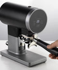 Automatic 58mm Electric Coffee Tamper With Height Adjustable Stand And Rock Solid Precision Press For Smooth Espresso Pulls, black metal finish, display panel, portafilter attached.