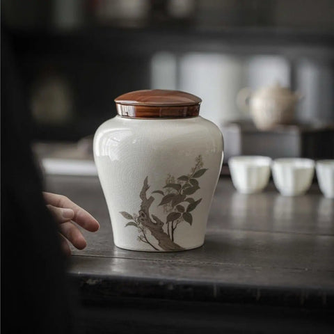 Heavy Duty Airtight Ceramic Tea Canister with decorative design on a wooden table for loose leaf tea, coffee, and dry goods.