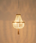 Four Light Wood Beaded Boho Farmhouse Pendant Chandelier With Tassels In White Rustic Bohemia Style, lit and hanging