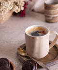 Premium Roll Paper Coffee Filters Compatible With Bunn Sure Immersion Drip Machine 5.5 Inch White 2 Roll Bulk Pack Yields 2944 Cups for brewing coffee in a ribbed mug with cookies.