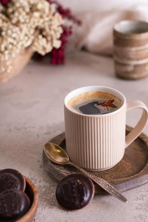 Premium Roll Paper Coffee Filters Compatible With Bunn Sure Immersion Drip Machine 5.5 Inch White 2 Roll Bulk Pack Yields 2944 Cups for brewing coffee in a ribbed mug with cookies.