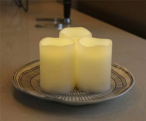 Outdoor IP44 Flameless LED Pillar Candles Set Of 3 With Remote And Timer Warm White Weather Resistant Plastic Candles That Wont Melt Waterproof 3 By 4 Inches Battery Operated on a plate