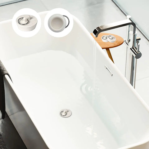 Heavy Duty Rubber Drain Stopper With Sturdy Pull Ring, Six Piece Set Of White Sink Plugs That Slickly Fit Most Bathtub And Kitchen Drains Daily in a modern white bathtub.