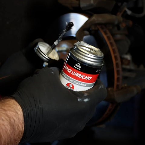 Person applying Premium 4oz Brush Top SIL Glyde Silicone Brake Grease for Calipers and Brake Lubrication, High Temperature Safe