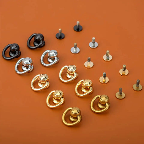 Top Tier 20 Pack Solid Brass Ball Chicago Studs Heavy Duty Screw Rivets With D Rings Badass Hardware For Leathercraft Belt Straps Wallet Chains And Diy Gear Gilt Gold Small assorted black, silver, and gold rivets on orange background