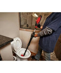 Using the Heavy Duty Cordless Drain Snake And Toilet Auger Set to clear a clogged toilet in a bathroom.