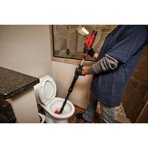 Using the Heavy Duty Cordless Drain Snake And Toilet Auger Set to clear a clogged toilet in a bathroom.