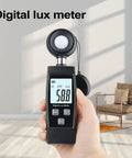 Handheld Lux Meter For Ambient Light Monitoring With MAX MIN Data Hold Digital Photometer Reads Up To 200000 Lux, shown in hand
