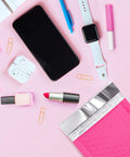 Hot Pink Bubble Mailers 4x8 Inch Pack Of 50 Waterproof Padded Envelopes next to phone, watch, and stationery on pink surface