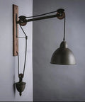 Badass Industrial Pulley Wall Sconce Featuring Solid Black Iron Rope Lighting with adjustable height and vintage design.