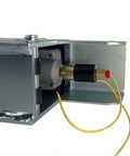Demco hydraulic surge brake actuator mounted in metal housing; brass piston, black cap, yellow solenoid wires