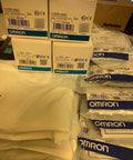Stack of Omron E3X-NA41 photoelectric sensors with packaging, ideal for automation lines, featuring precise sensing with fiber optic cable.