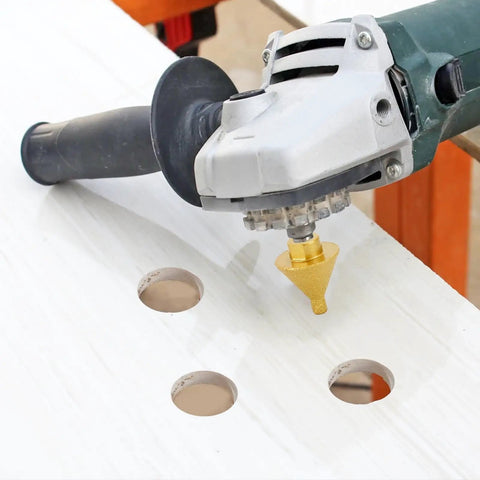 Beveling Chamfer Bit With Diamond Cone Tile Bit 1.5 Inch Countersink Drill Bit For Hole Enlarging And Trimming In Tile Granite Marble Ceramic Wood M10 Thread Fits Most Angle Grinders being used with angle grinder on white tile surface showing three enlarged holes.