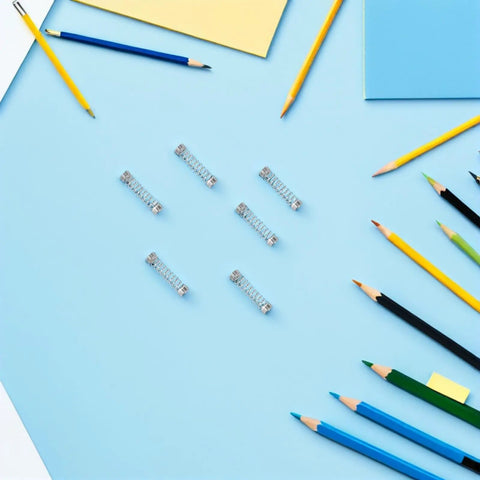 Top Tier 100 Pack Stainless Steel Compression Springs Kit For Ballpoint Pen Click Return Repair DIY Mechanical Tool Refurbishing Gear Silver Tone on blue background with pencils