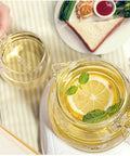 Sleek Heat Resistant Glass Teapot For Cold Brew And Hot Tea, Smooth Drip Pour Spout Juice Pitcher, Solid Borosilicate Server With Comfy Grip Handle, Lead Free Kitchen Essential For Daily Grind with lemon slices and mint leaves.