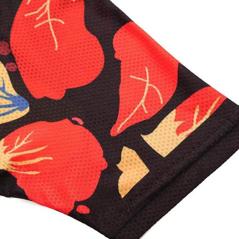Close-up of black fabric with vibrant red and beige abstract patterns.