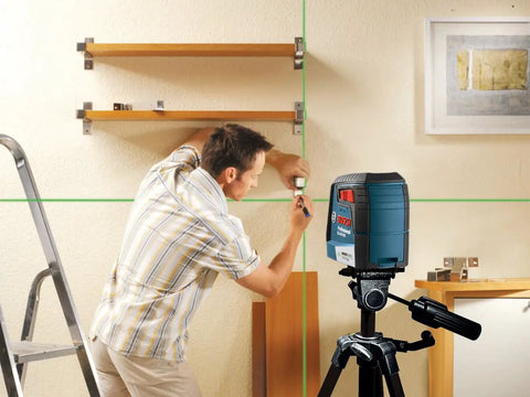 Green Beam Self-Leveling Cross-Line Laser Kit With 40 Ft Range used for precise shelf installation on a job site.