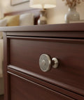 Kick Up Your Cabinet Game With These Premium Brushed Satin Nickel Round Knobs, 10 Pack, showcasing delicate filigree cutouts on a drawer.