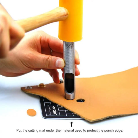 Using 12 Piece Leather Hole Punch Set With Free Cutting Mat on leather with a hammer, showing ergonomic non-slip handles.