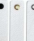 Three white leather drawer pulls with black, gold, and silver buttons, part of the Two Pack White Leather Drawer Pulls For Industrial Style Furniture Upgrade.
