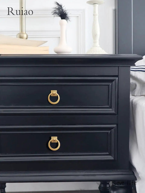 Black dresser with gold ring drawer knobs installed