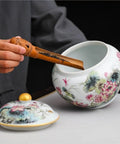 Hand-Painted Floral Ceramic Tea Canister With Legit Airtight Seal For Loose Tea, Coffee Beans, And Pantry Staples being filled with tea.