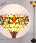 Tiffany Style Floor Lamp with 12 Inch Stained Glass Shade 71 Inch Tall Antique Bronze Base Uplight Torchier turned on.