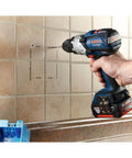 Side view of blue and black Bosch cordless drill drilling into ceramic tile.