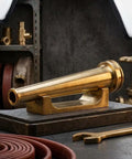 Top Tier Heavy Duty Brass Fire Nozzle 1.5 Inch Nst Fitting, solid brass material on a display stand for firefighting use.