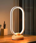 Modern Ellipse LED Desk Lamp With Wood Accent on nightstand, dimmable warm white light, cozy vibes lighting, sleek aluminum edge