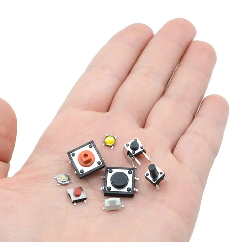 Hand holding various micro momentary tactile push button switches from 240 Piece Micro Momentary Tactile Push Button Switches Assortment Kit