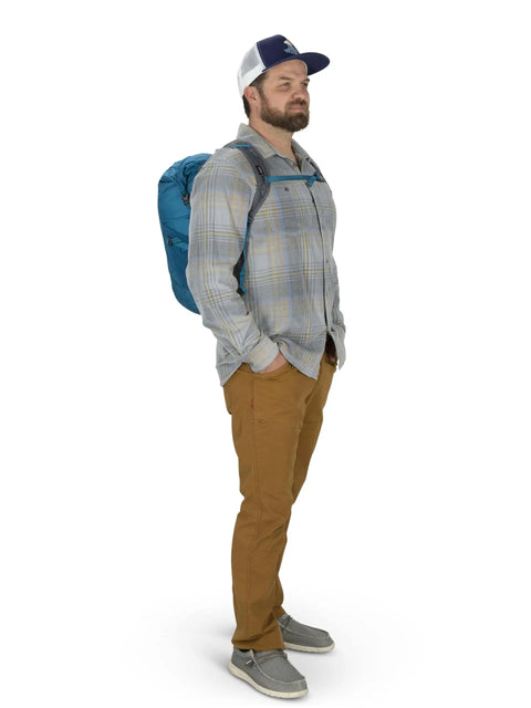 Man modeling Ultralight 20L Dry Stuff Pack for Travel and Quick Day Trips with Roll Top Waterproof Closure, blue backpack, side view